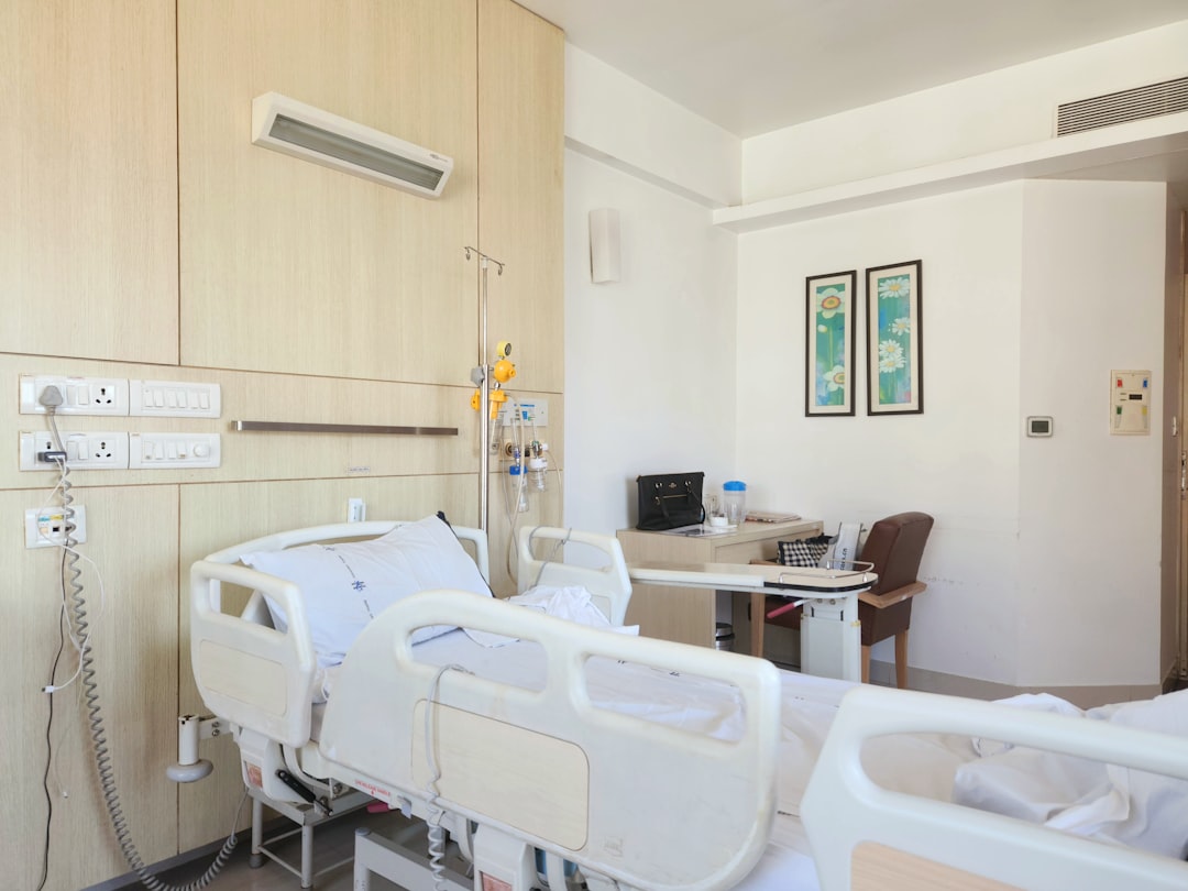A hospital room with empty beds and medical equipment, depicting a healthcare environment.